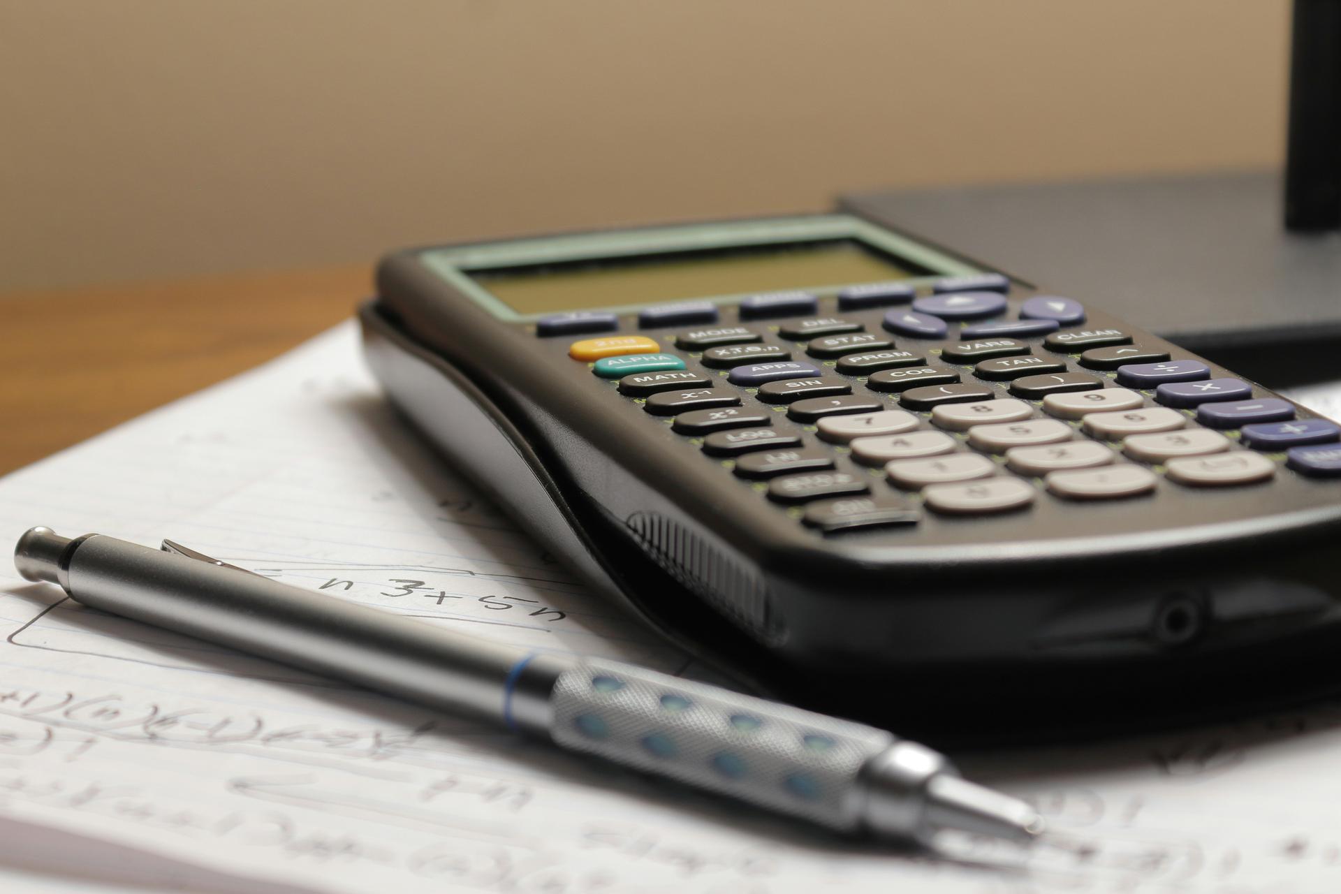 Calculator and coins representing interest charges on debts